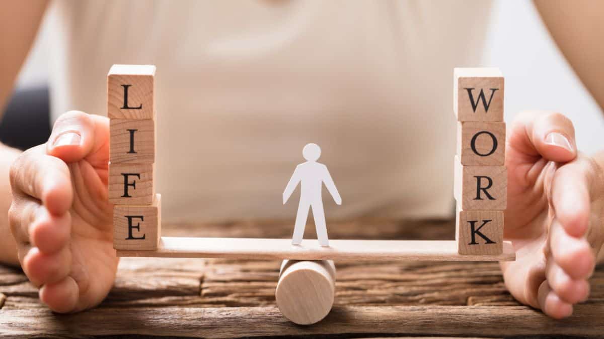 A figure trying to balance work and life on a board plank